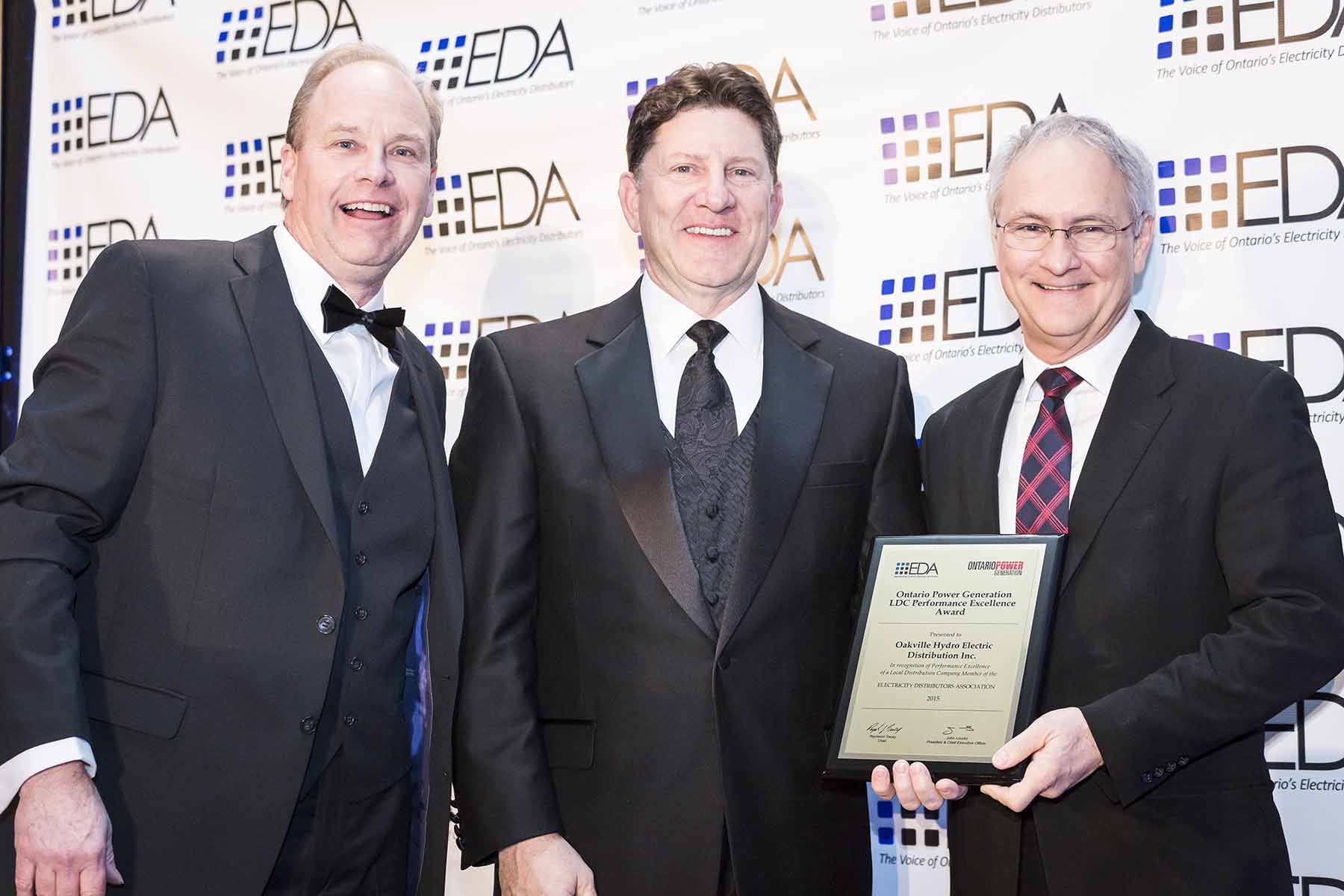 EDA representatives and Oakville Hydro CEO Rob Lister pose with the award