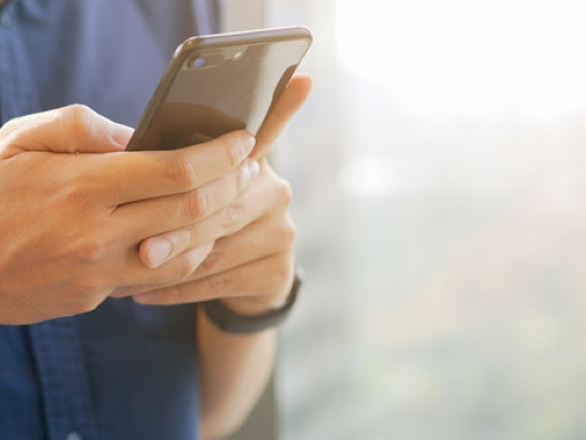 Hands holding a cell phone typing on it