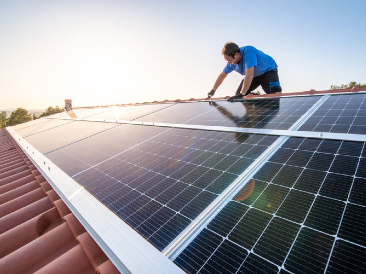 Man on a roof installing solar panels 