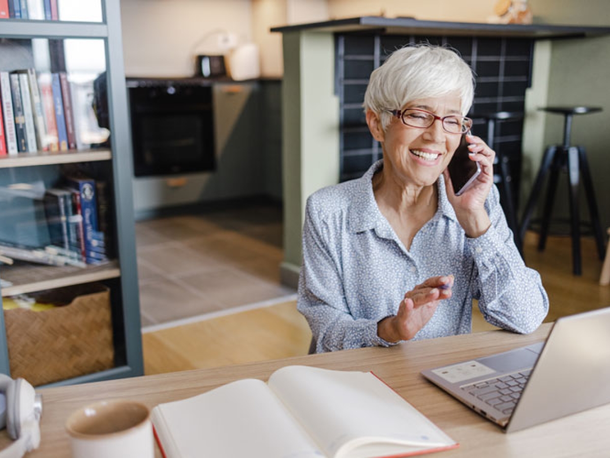 Elderly women smiling while speaking on a phone