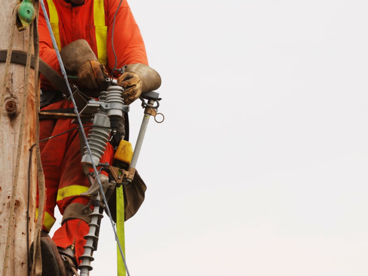 Closeup of a lineperson who has climbed a pole