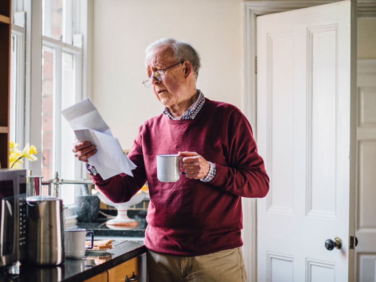 Elderly man looking at his bill Elderly man looking at his bill